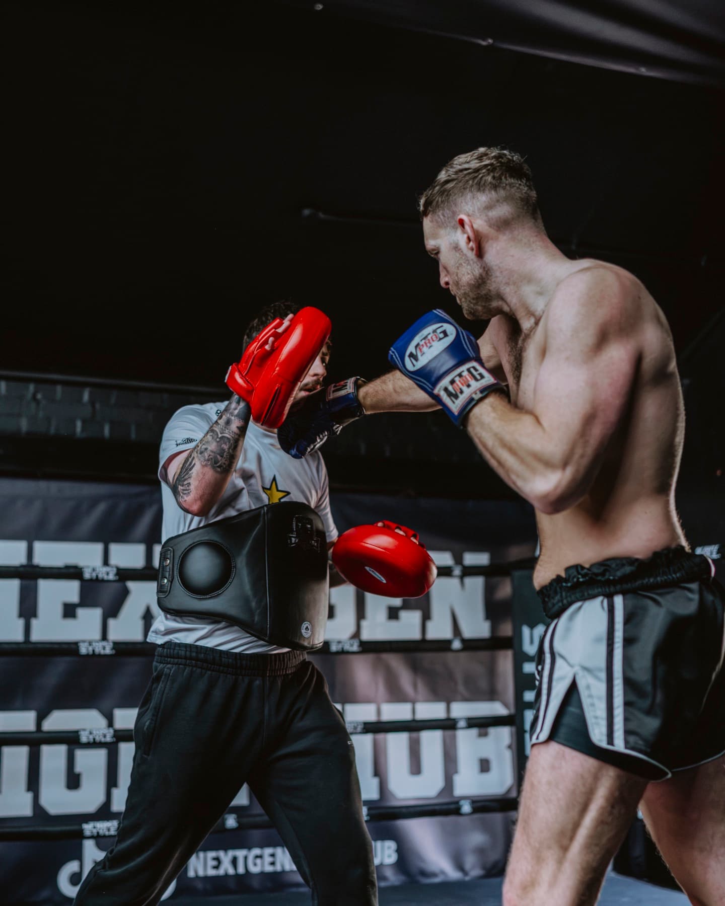 Hayden driving a straight punch into the pads in the ring at Next Gen Fight Hub