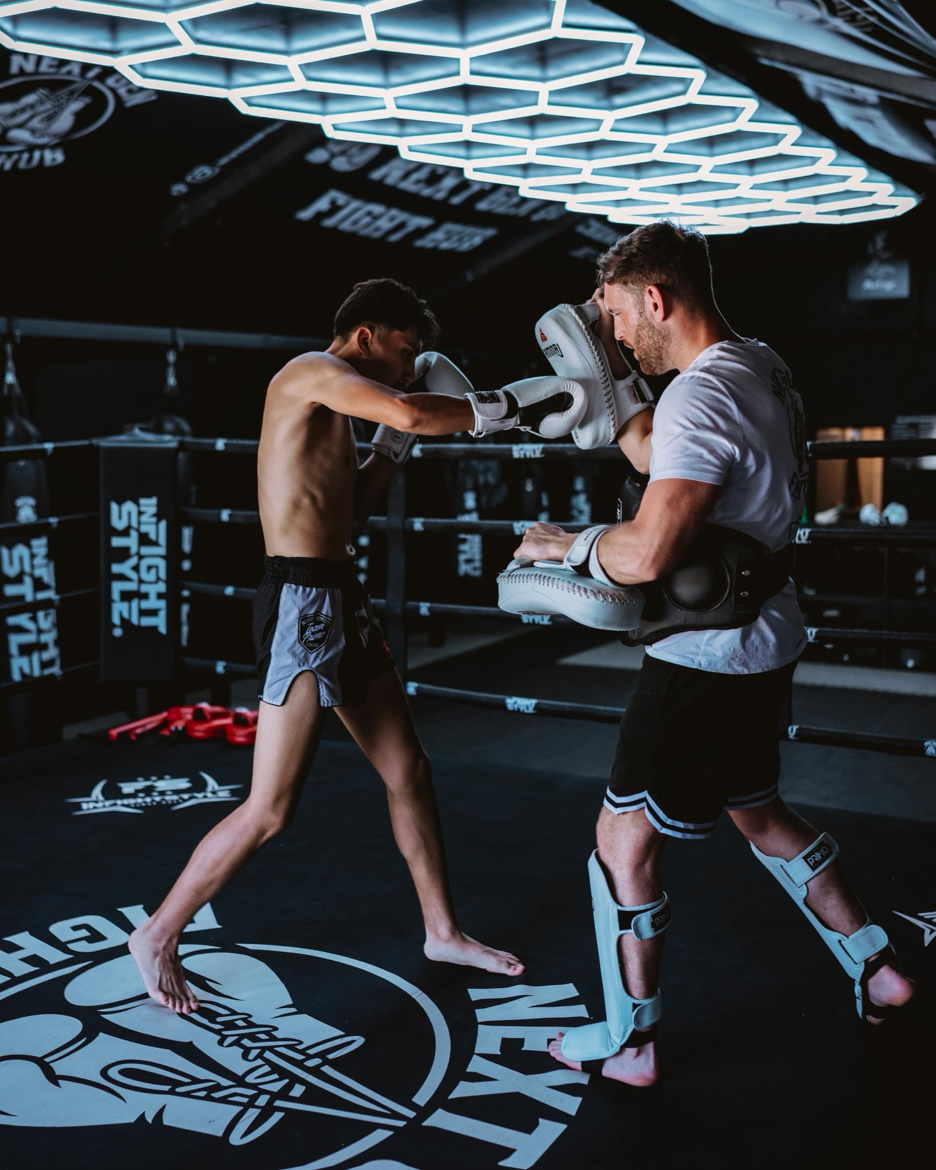 Hayden holding the pads for a punching combination at Next Gen Fight Hub