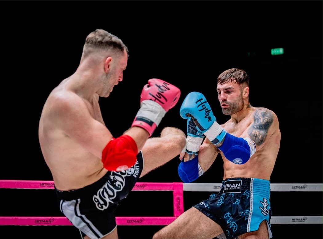 Hayden and his opponent trading kicks in the ring at the Hitman Fight League
